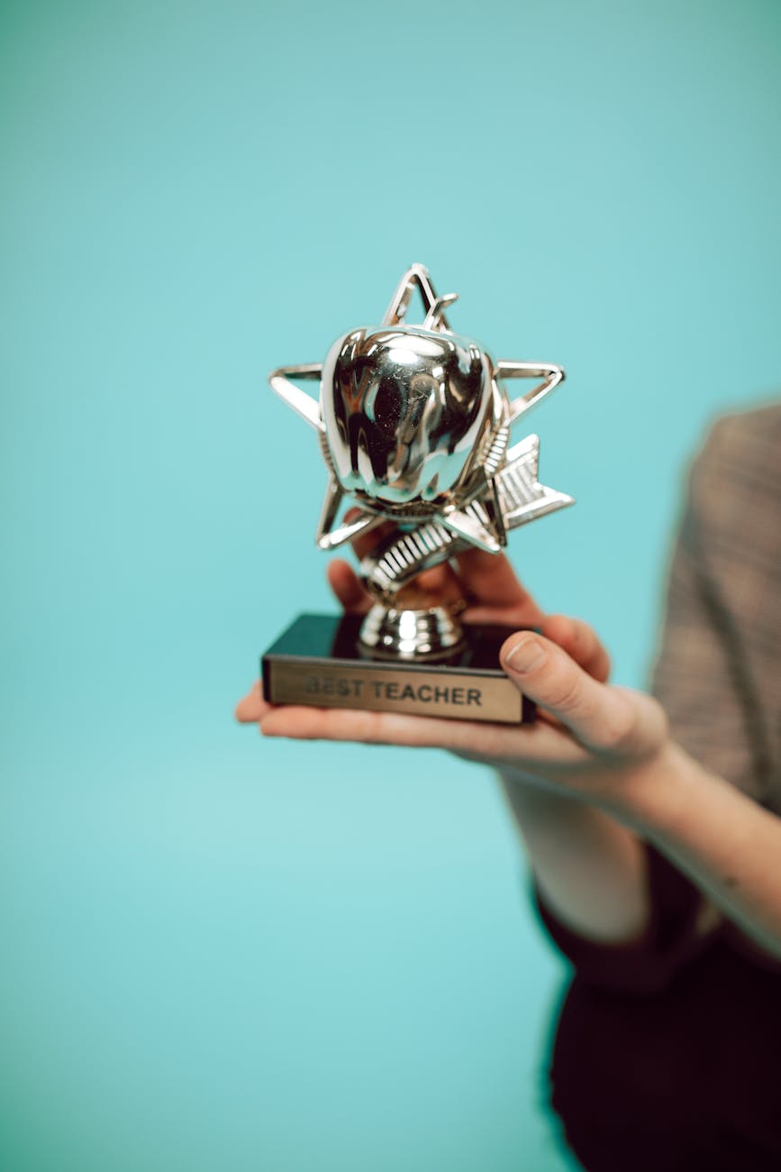 person holding silver trophy